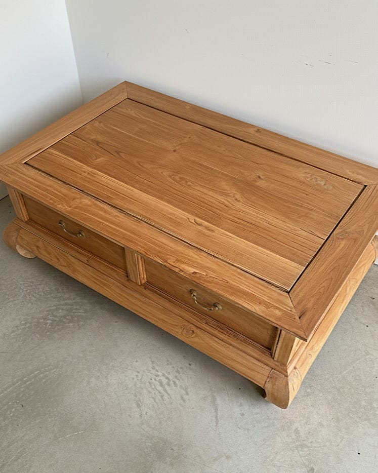 Table basse d'inspiration asiatique en bois massif après rénovation par aérogommage, posée sur un parquet avec une plante verte. — photo 4