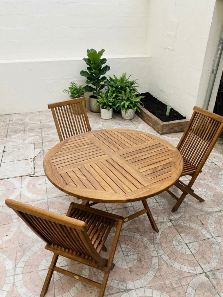 Salon de jardin en teck avant et après aérogommage : le bois grisaillé retrouve sa teinte chaude et naturelle après décapage.